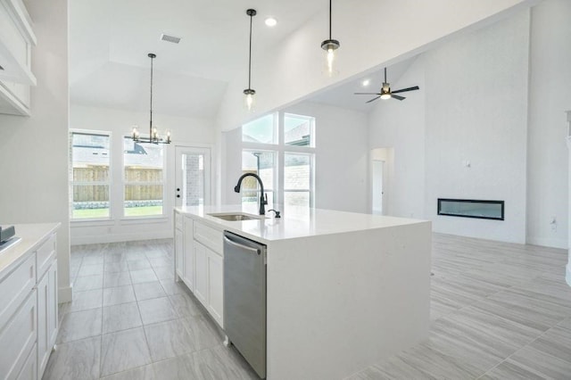 kitchen featuring stainless steel dishwasher, sink, high vaulted ceiling, white cabinets, and an island with sink