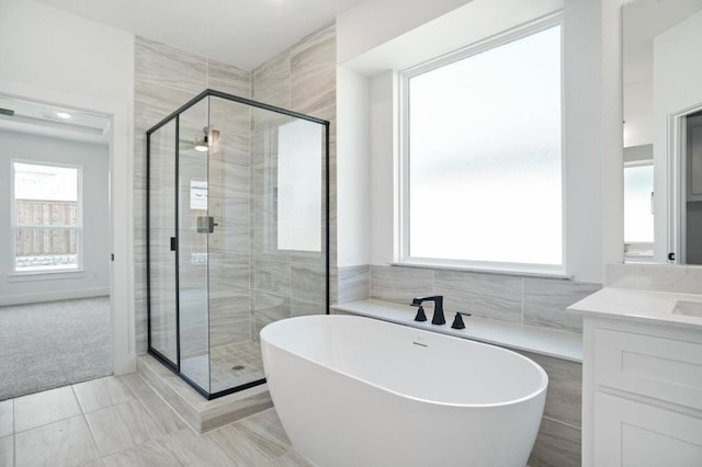 bathroom with vanity, plus walk in shower, and tile walls