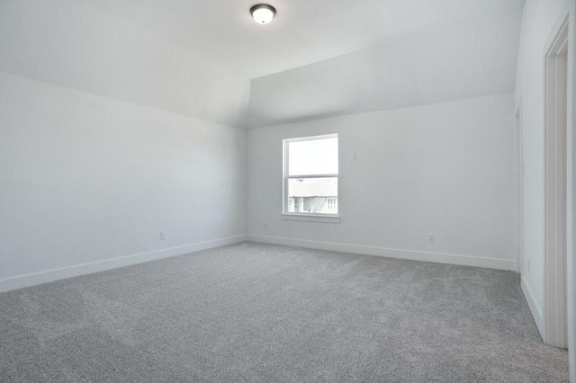 empty room with light carpet and lofted ceiling