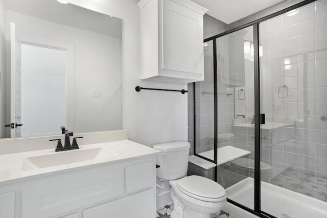 bathroom featuring vanity, toilet, and a shower with shower door