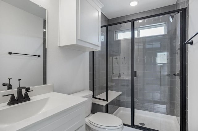 bathroom featuring vanity, toilet, and a shower with shower door