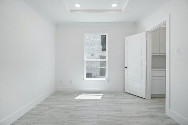 spare room featuring a tray ceiling and crown molding