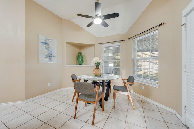 dining area with light tile patterned flooring, ceiling fan, and vaulted ceiling