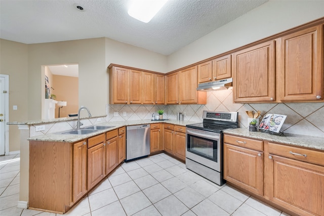 kitchen featuring kitchen peninsula, light stone countertops, a textured ceiling, stainless steel appliances, and sink