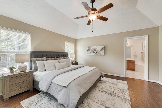 bedroom featuring lofted ceiling, a textured ceiling, and light hardwood / wood-style flooring