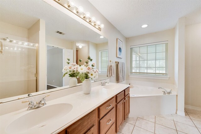 bathroom featuring a washtub, a textured ceiling, and vanity