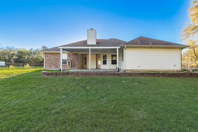 back of house featuring a lawn and a patio