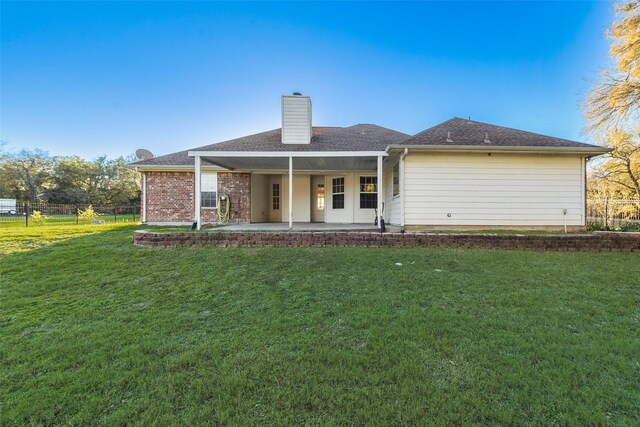 back of house featuring a lawn