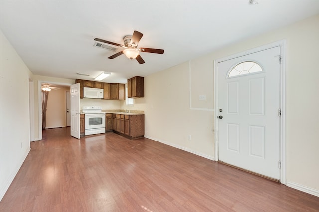 interior space featuring hardwood / wood-style flooring, white appliances, ceiling fan, and sink