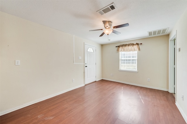 spare room with hardwood / wood-style flooring, ceiling fan, and a textured ceiling