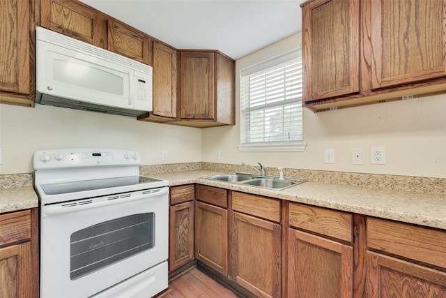 kitchen featuring sink, white appliances, and light hardwood / wood-style flooring