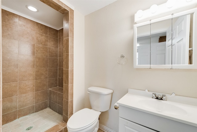 bathroom featuring vanity, toilet, and a tile shower