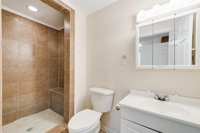 bathroom featuring vanity, toilet, and tiled shower