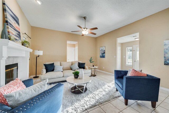 tiled living room with a textured ceiling and ceiling fan