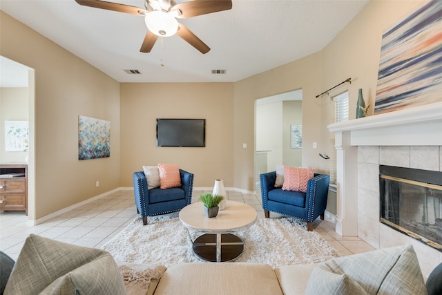 living room featuring ceiling fan, light tile patterned flooring, and a tile fireplace