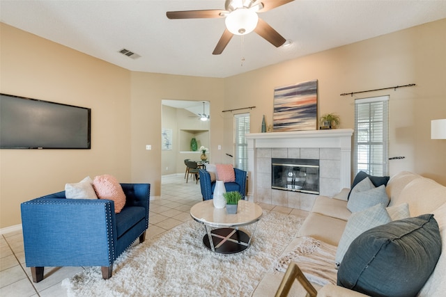 living room with light tile patterned floors and a tile fireplace