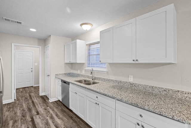 kitchen with dark hardwood / wood-style floors, sink, white cabinets, stainless steel dishwasher, and light stone countertops