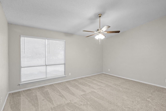 carpeted spare room with ceiling fan, vaulted ceiling, and a textured ceiling