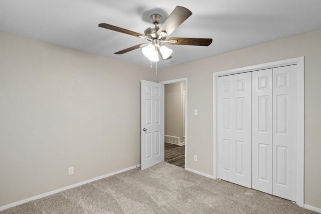 unfurnished bedroom featuring light colored carpet, ceiling fan, and a closet