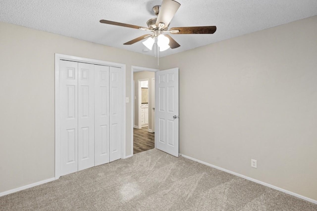 unfurnished bedroom with ceiling fan, a closet, carpet floors, and a textured ceiling