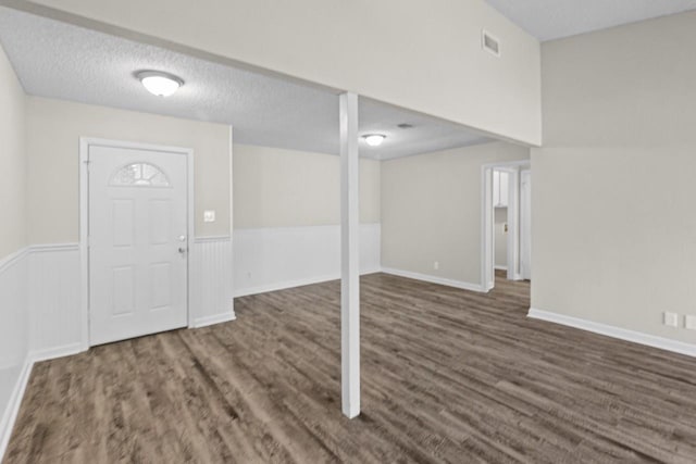 entryway with dark wood-type flooring and a textured ceiling