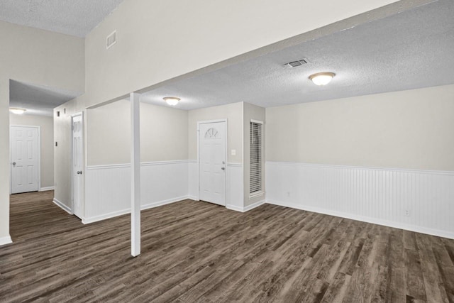 basement featuring dark hardwood / wood-style floors and a textured ceiling