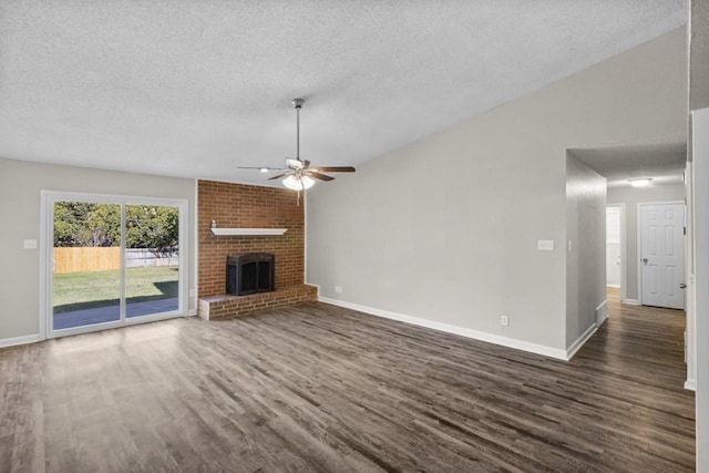 unfurnished living room featuring dark wood-type flooring, a fireplace, vaulted ceiling, and a textured ceiling