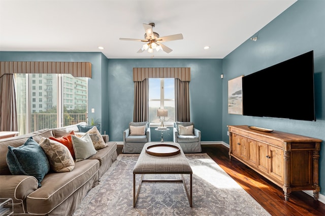 living room with ceiling fan and dark hardwood / wood-style flooring