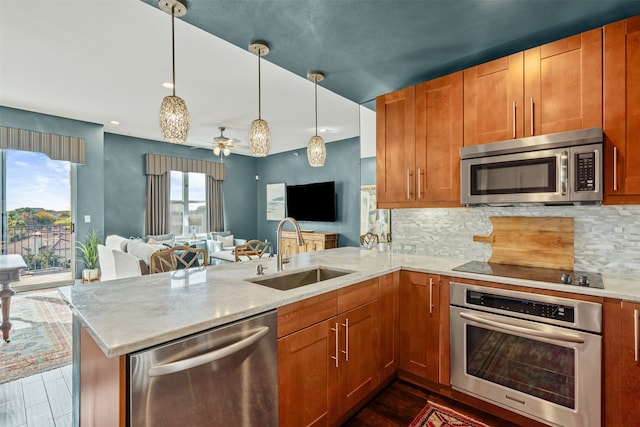 kitchen featuring hanging light fixtures, kitchen peninsula, sink, and stainless steel appliances