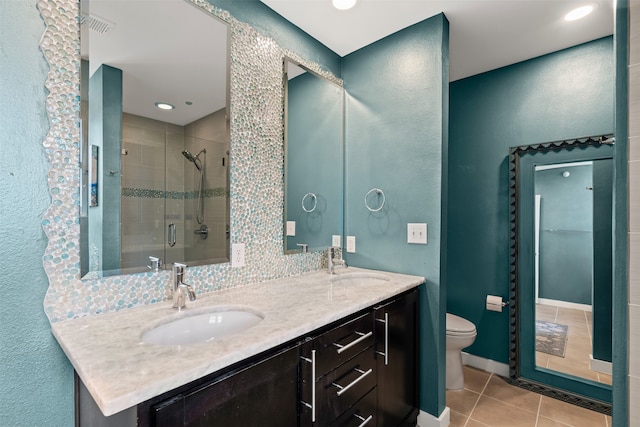 bathroom with tile patterned flooring, vanity, a shower with shower door, and toilet