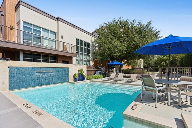 view of pool featuring pool water feature and a patio area