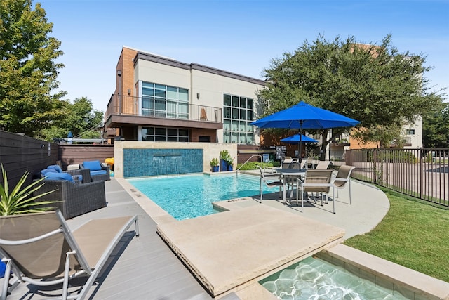 view of swimming pool featuring pool water feature, an outdoor living space, and a patio area