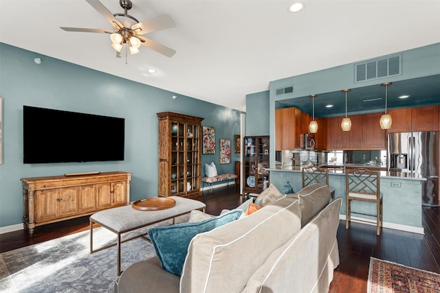 living room with dark wood-type flooring and ceiling fan