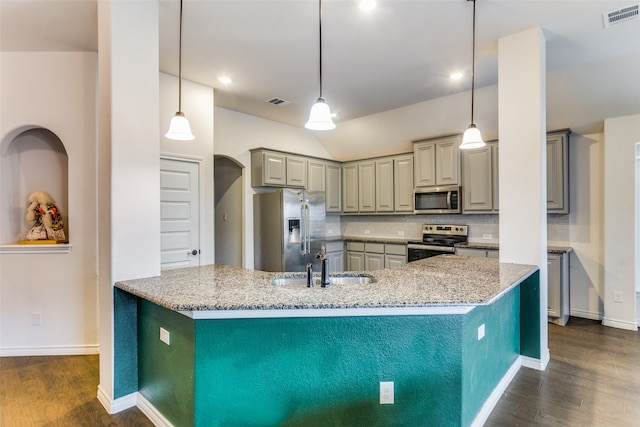 kitchen featuring stainless steel appliances, tasteful backsplash, light stone countertops, and decorative light fixtures