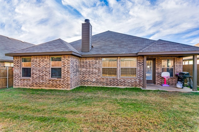 back of house with a yard and a patio