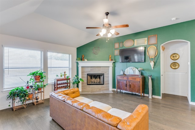 living room with hardwood / wood-style floors, ceiling fan, lofted ceiling, and a tiled fireplace