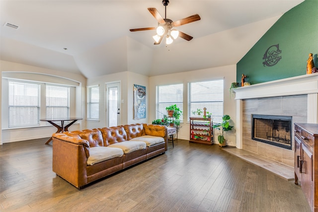 living room with a tile fireplace, hardwood / wood-style flooring, ceiling fan, and lofted ceiling