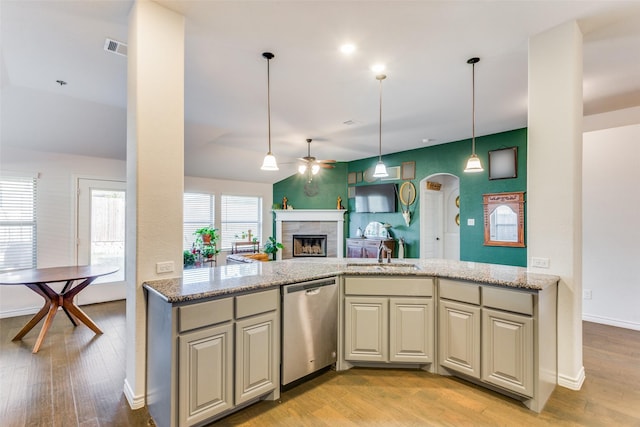 kitchen with light stone countertops, dishwasher, sink, and light hardwood / wood-style flooring