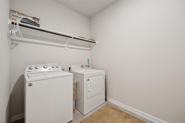 clothes washing area with light tile patterned floors and washing machine and dryer