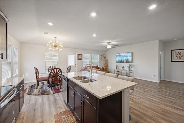 kitchen featuring sink, an island with sink, decorative light fixtures, ceiling fan with notable chandelier, and appliances with stainless steel finishes