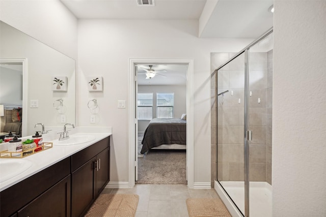 bathroom featuring tile patterned flooring, ceiling fan, a shower with shower door, and vanity