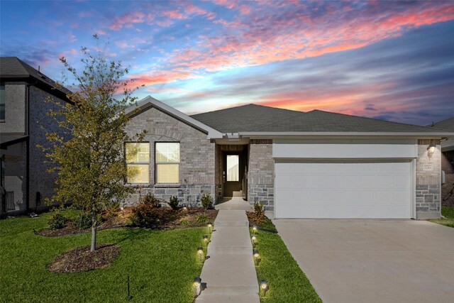 view of front of house featuring a garage and a yard