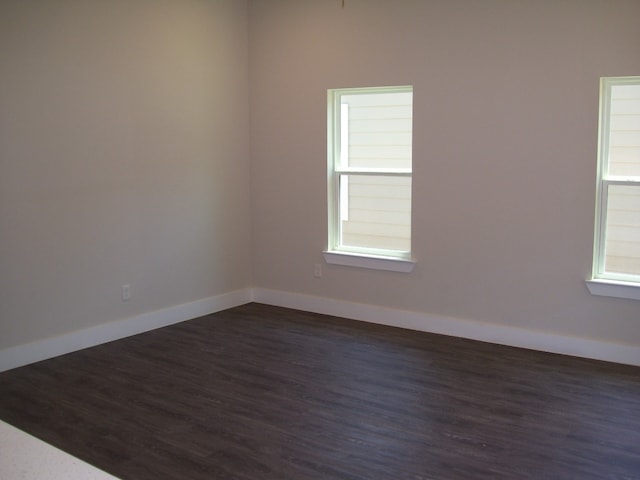 unfurnished room with dark hardwood / wood-style flooring