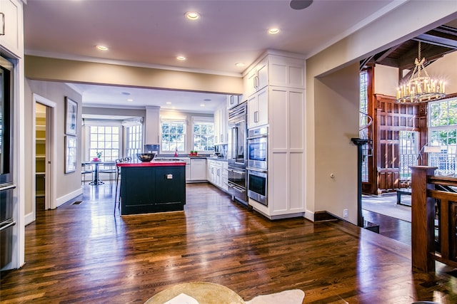 kitchen featuring a wealth of natural light, white cabinetry, and dark wood-type flooring