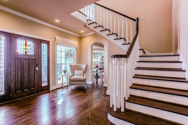 foyer with dark wood-type flooring and ornamental molding