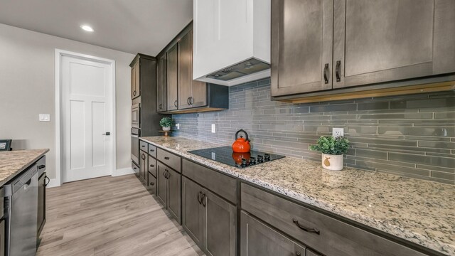 kitchen featuring a kitchen island with sink, sink, ceiling fan, light wood-type flooring, and decorative light fixtures