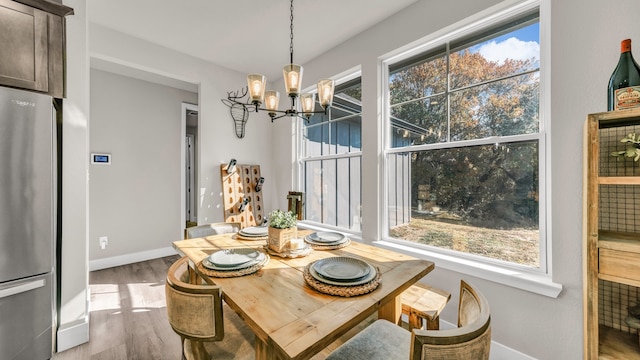 dining space featuring light hardwood / wood-style flooring and an inviting chandelier