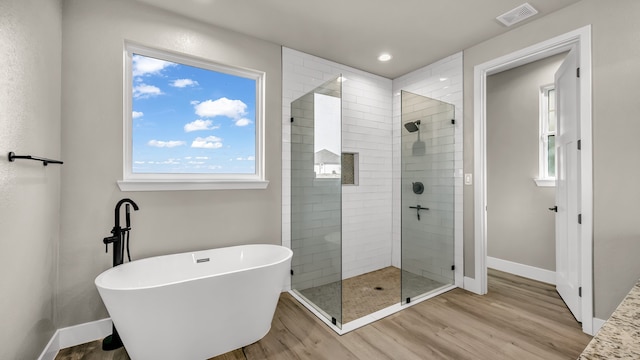 bathroom featuring shower with separate bathtub and hardwood / wood-style flooring