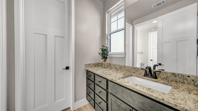 bathroom featuring hardwood / wood-style floors, vanity, and toilet