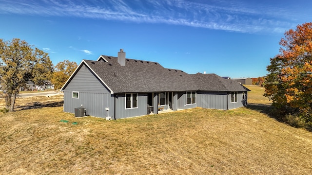 back of property featuring a lawn and central air condition unit